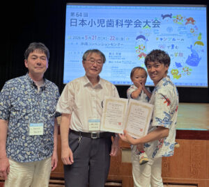 受賞した田中亜生助教と子供(右)、櫻井敦朗准教授(左)、新谷誠康教授